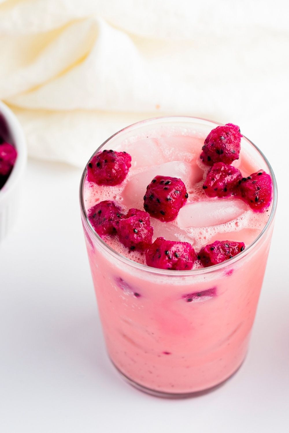 Cold Starbucks Dragon Drink with Diced Dragon Fruit and Ice in a Tall Glass