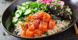 Homemade Salmon Poke Bowl with Rice, Cucumber and Seaweeds