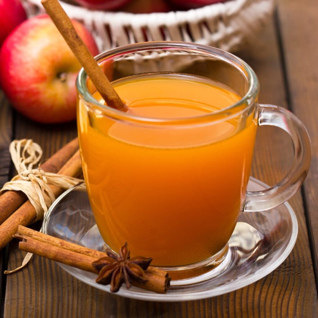 Apple Cider in a Glass Mug With Cinnamon Sticks