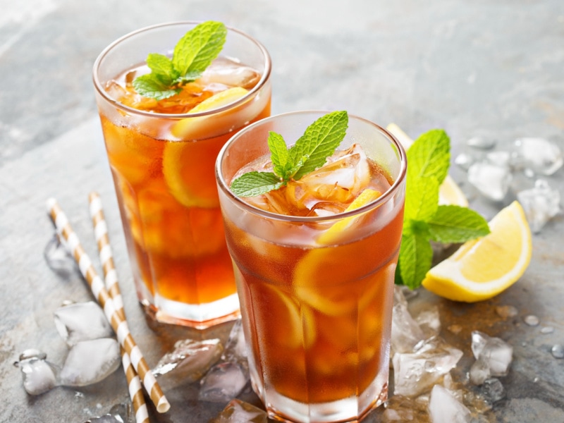 Two Tall Glasses of Iced Tea with Lemon and Mint Leaves