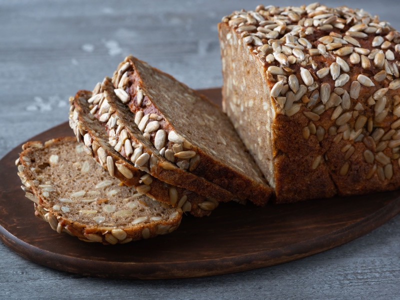 Loaf of Rye Bread Sliced on a Wooden Cutting Board