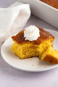 Sliced Homemade Lemon Poke Cake with Whipped Cream