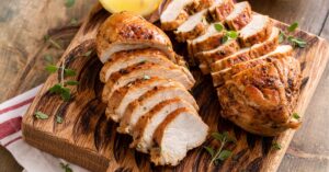 Sliced Crockpot Chicken Breast on a Wooden Board