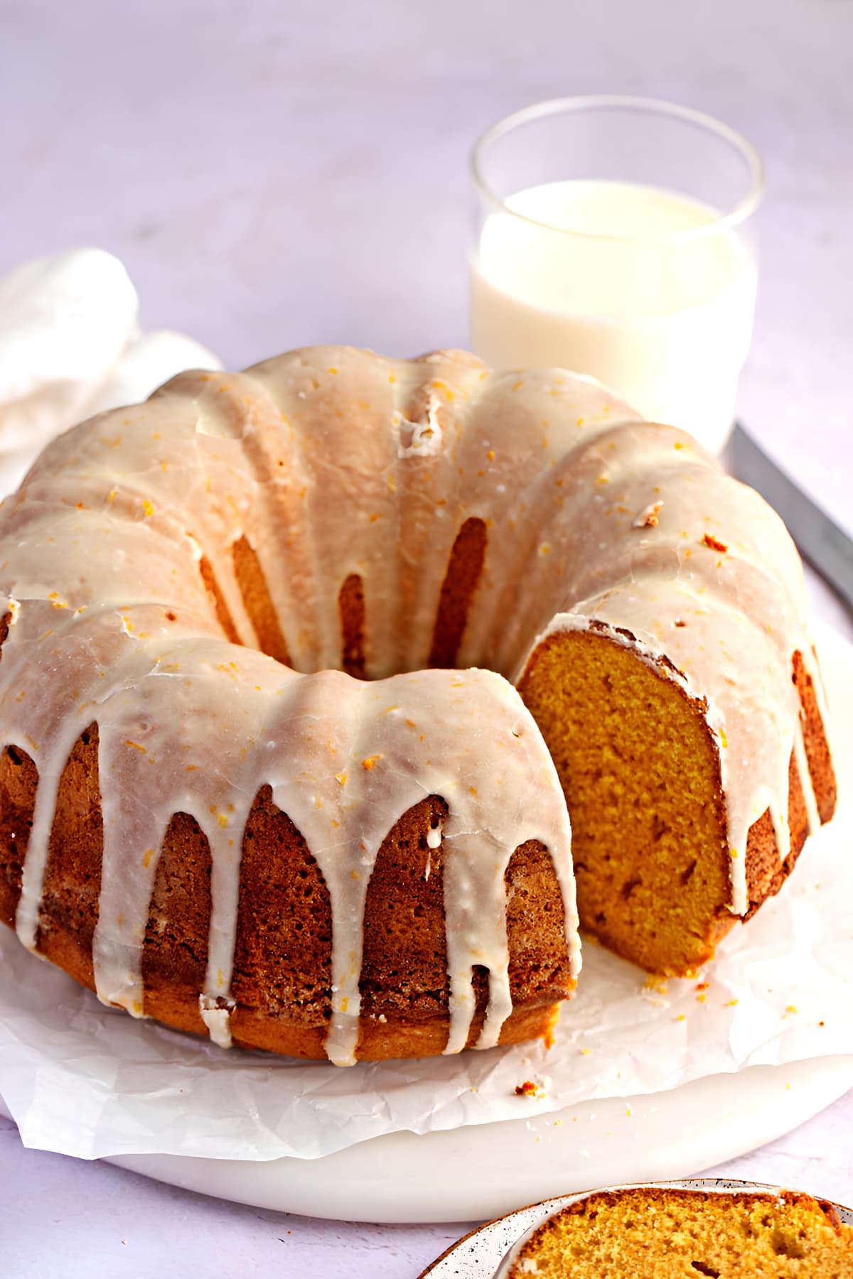 Sweet Potato Bundt Cake Sitting on a Plate Next to a Glass of Milk