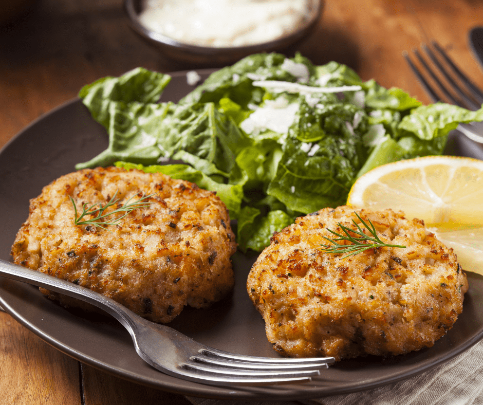 Crab Cakes on a plate with Salad And Lemon